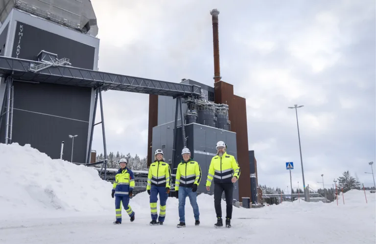 Työntekijät kävelevät voimalaitoksen pihalla.